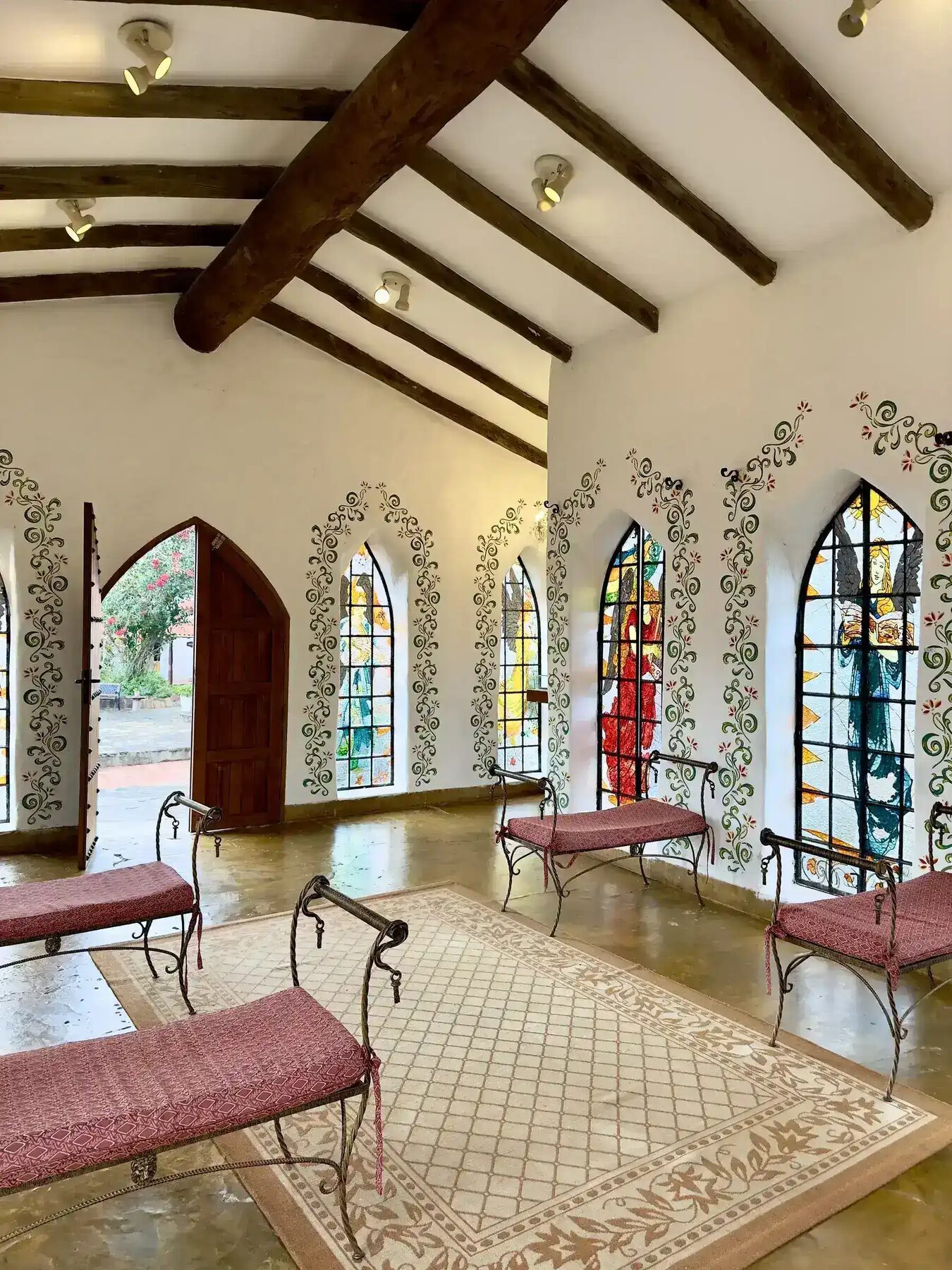 The chapel at El Pueblito, stained glass in arched windows and hand-painted vines on white walls